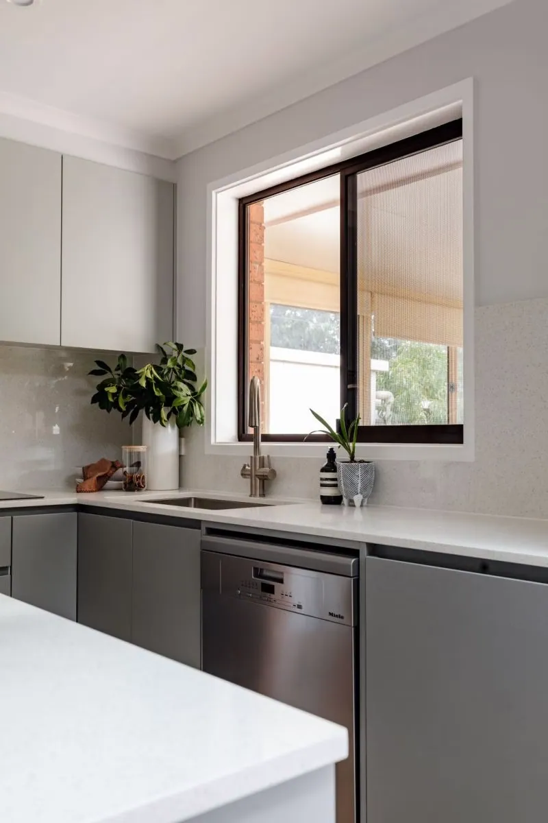 Grey cabinetry and white island benchtop in the Belconnen kitchen