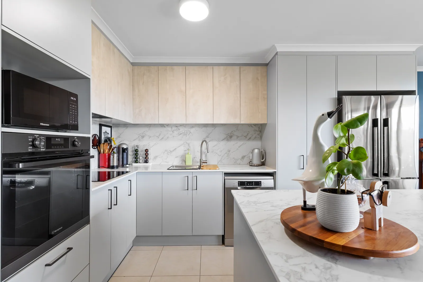 Bruce kitchen bench runs with black appliances and timber-look overhead cabinetry