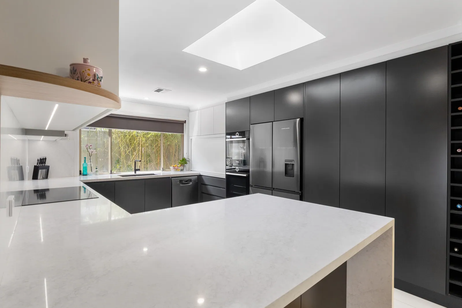 Calwell kitchen with black cabinetry, white benchtops and a skylight