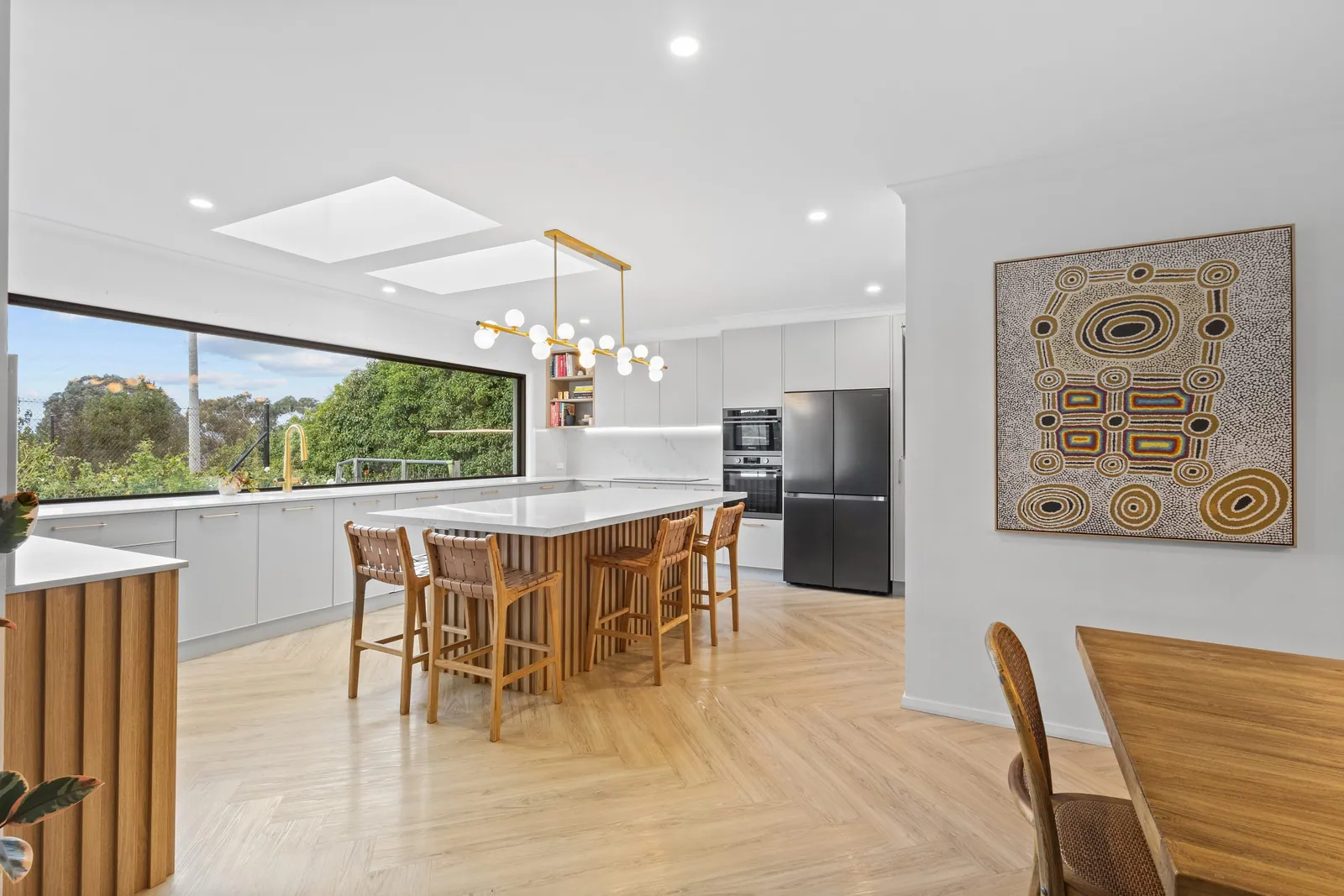 Chapman kitchen and dining space with a long window splashback and pendant lighting