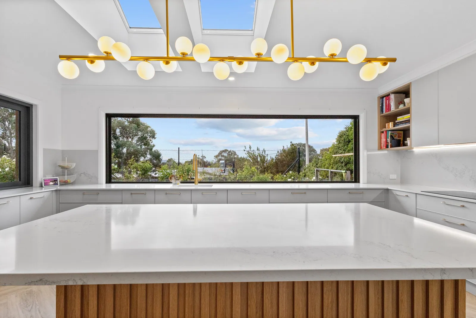 Long window splashback above the white bench run in the Chapman kitchen