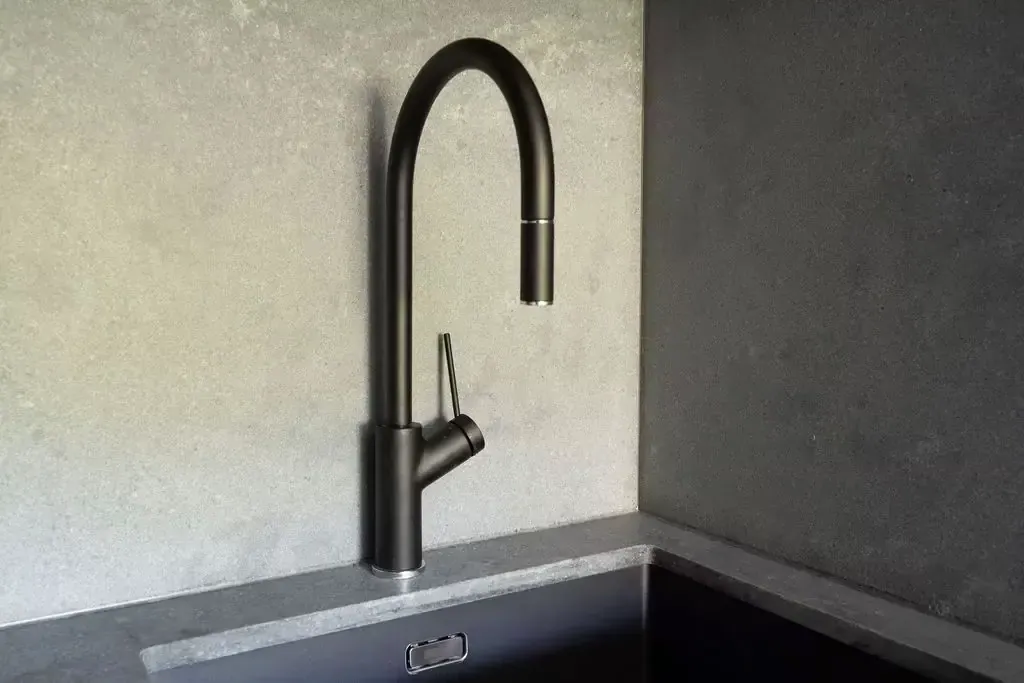 Black tapware and undermount sink against the concrete-look surface in the Deakin kitchen