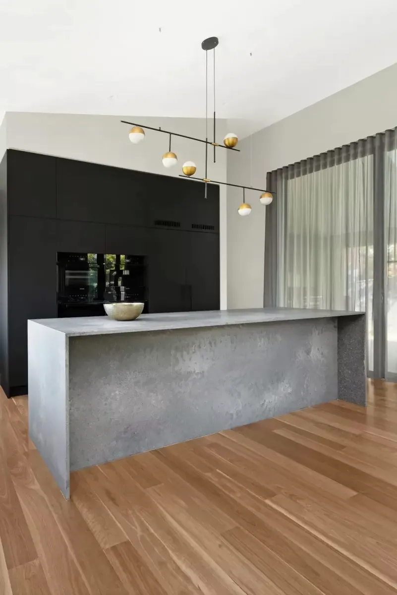 Long concrete-look island running through the open Deakin kitchen and living space