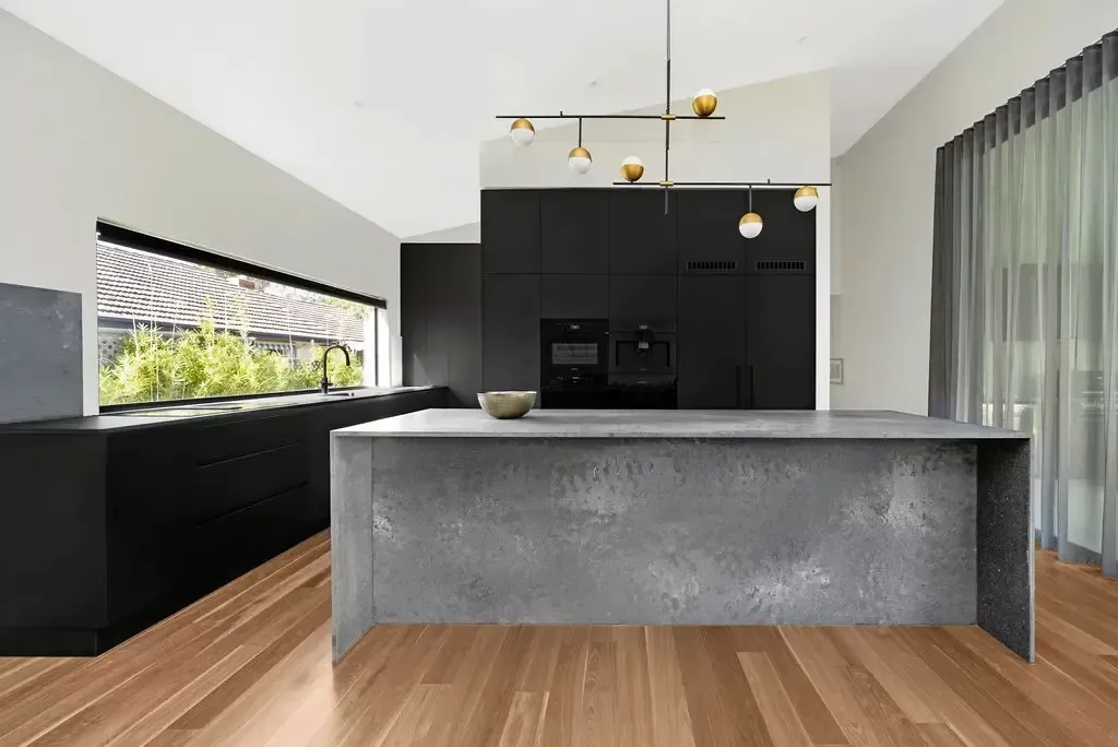 Deakin kitchen island seen from the living area with sheer curtains behind