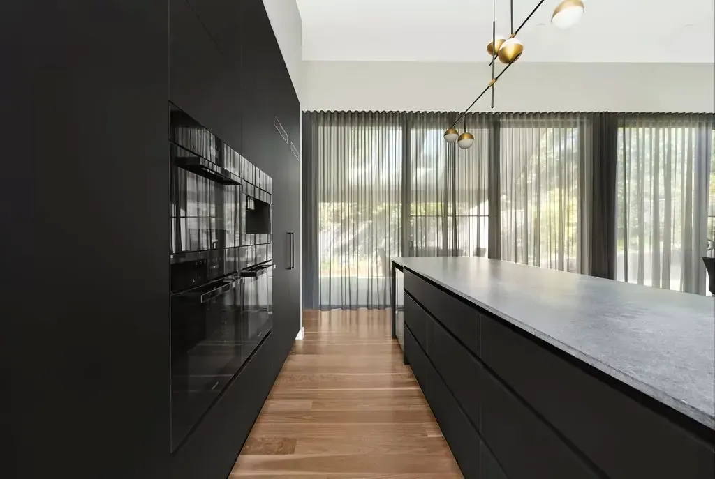Black joinery wall and integrated appliances in the Deakin kitchen