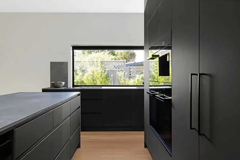 Black cabinetry, dark benchtop and window in the Deakin kitchen