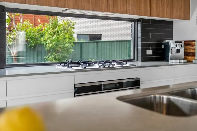 Gas cooktop and dark splashback in the Flynn kitchen