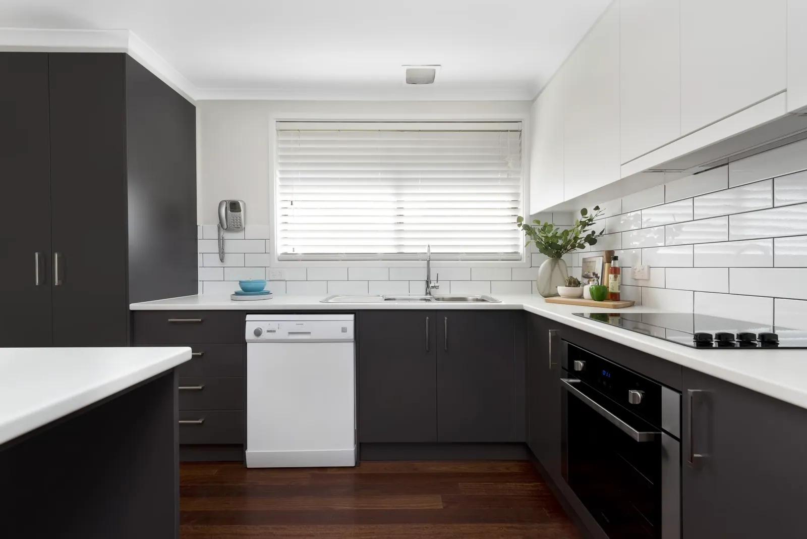 Dark grey and white cabinetry with a subway tiled splashback in the Giralang kitchen