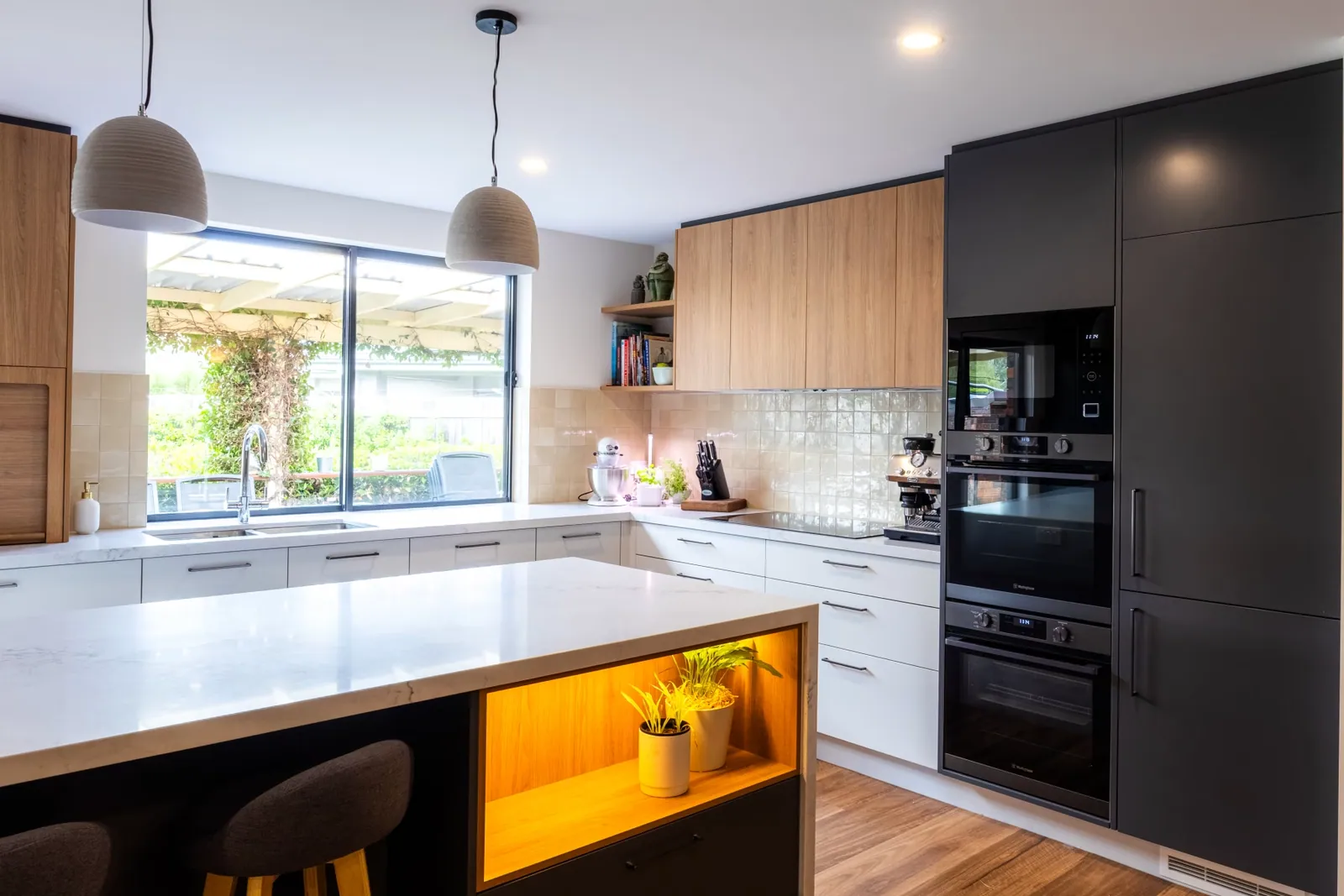 Dark grey appliance tower and timbergrain overheads in the Kaleen kitchen