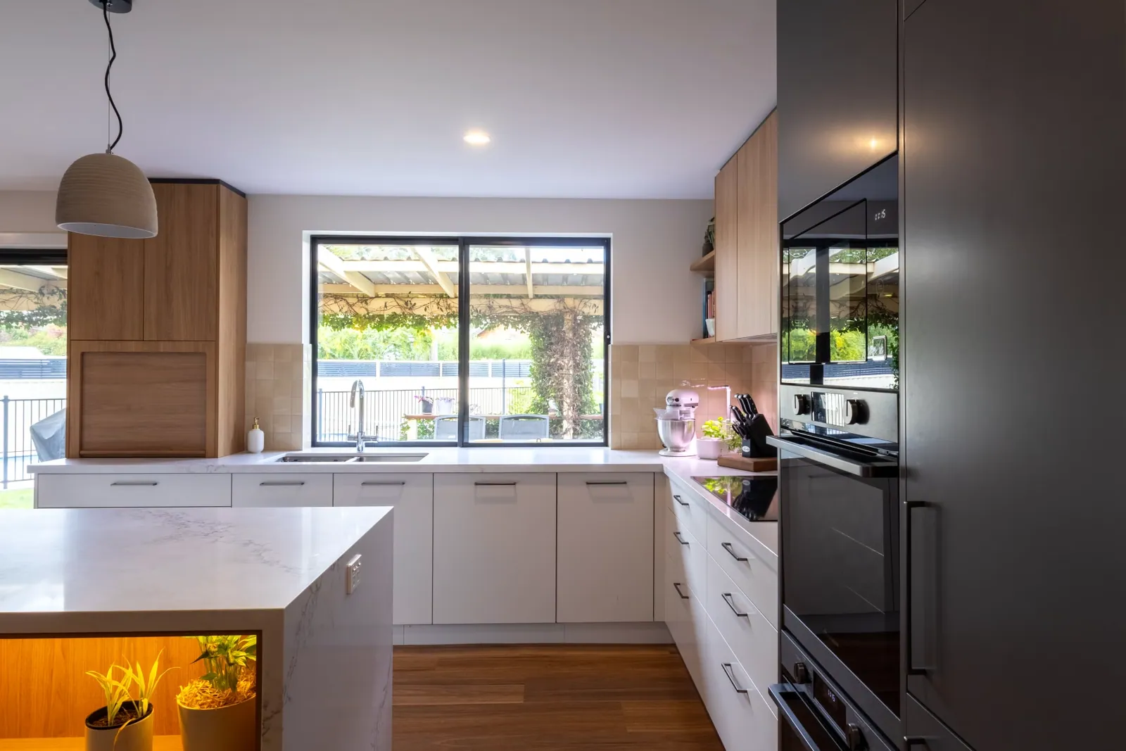 White bench run and window in the Kaleen kitchen with dark grey cabinetry opposite