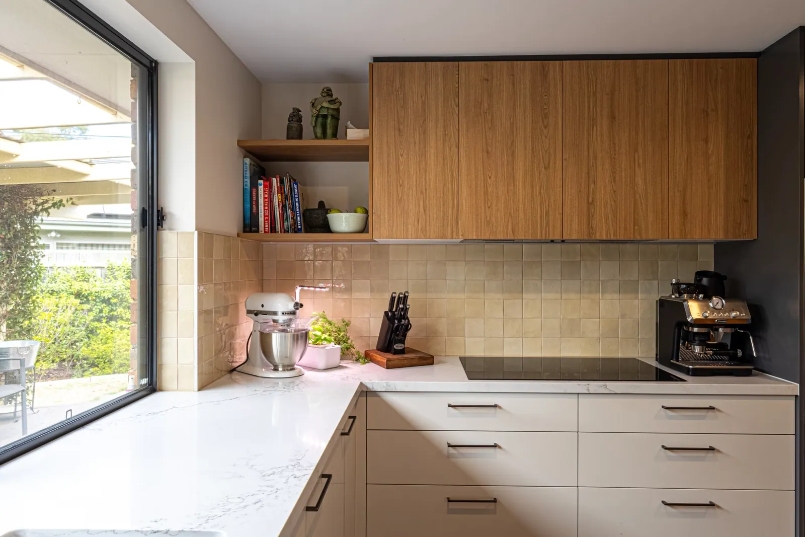 Timbergrain overhead cabinetry and open shelving above the Kaleen bench
