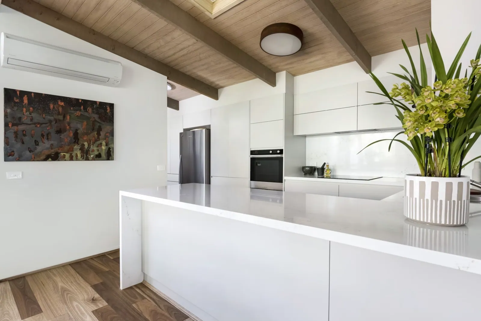 White island and bench runs under the timber-lined ceiling in the Mawson kitchen
