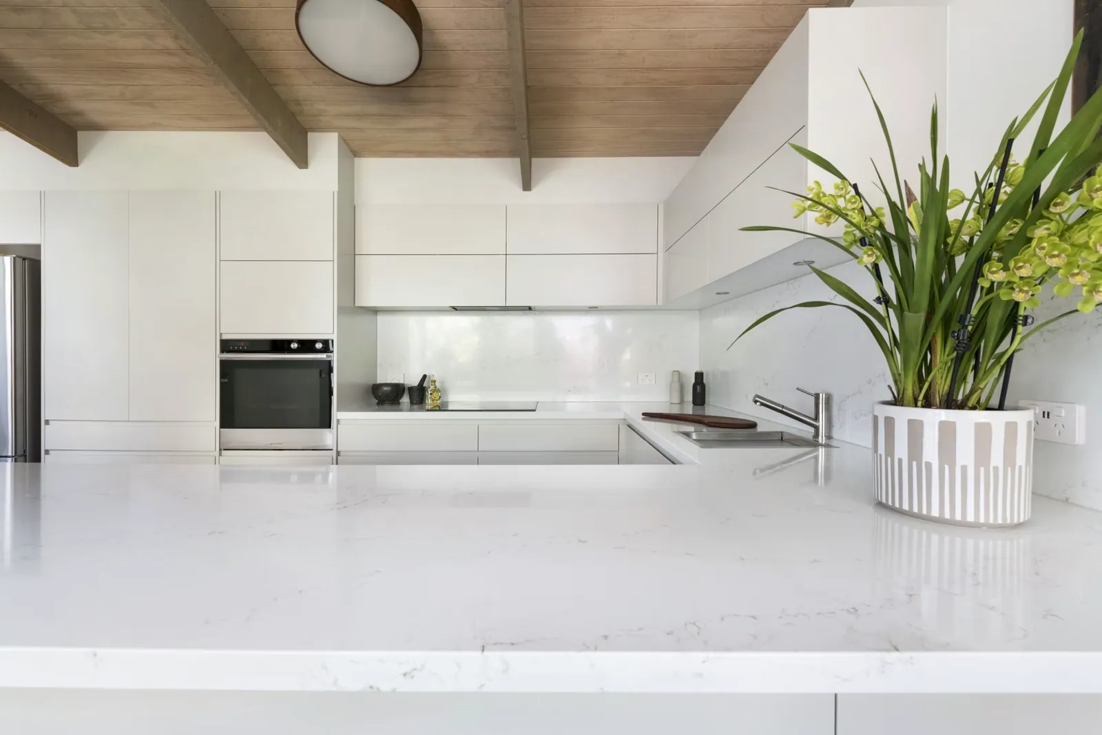 White benchtop and long bench run in the Mawson kitchen