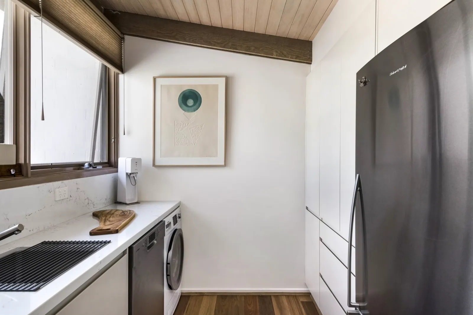 Timber flooring and white joinery beside the Mawson kitchen