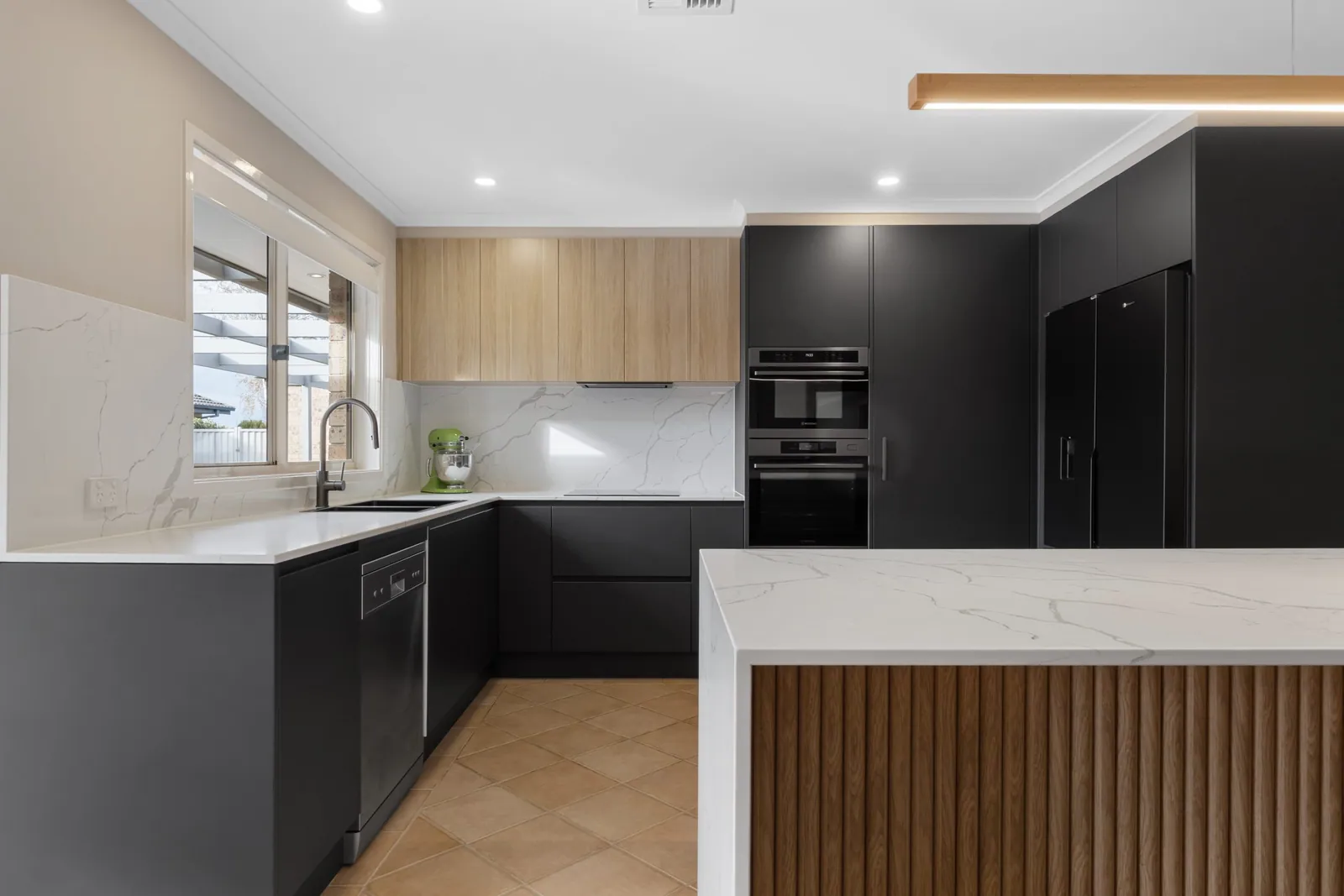 Nicholls kitchen with black handleless cabinetry, timber overheads and a stone-look island