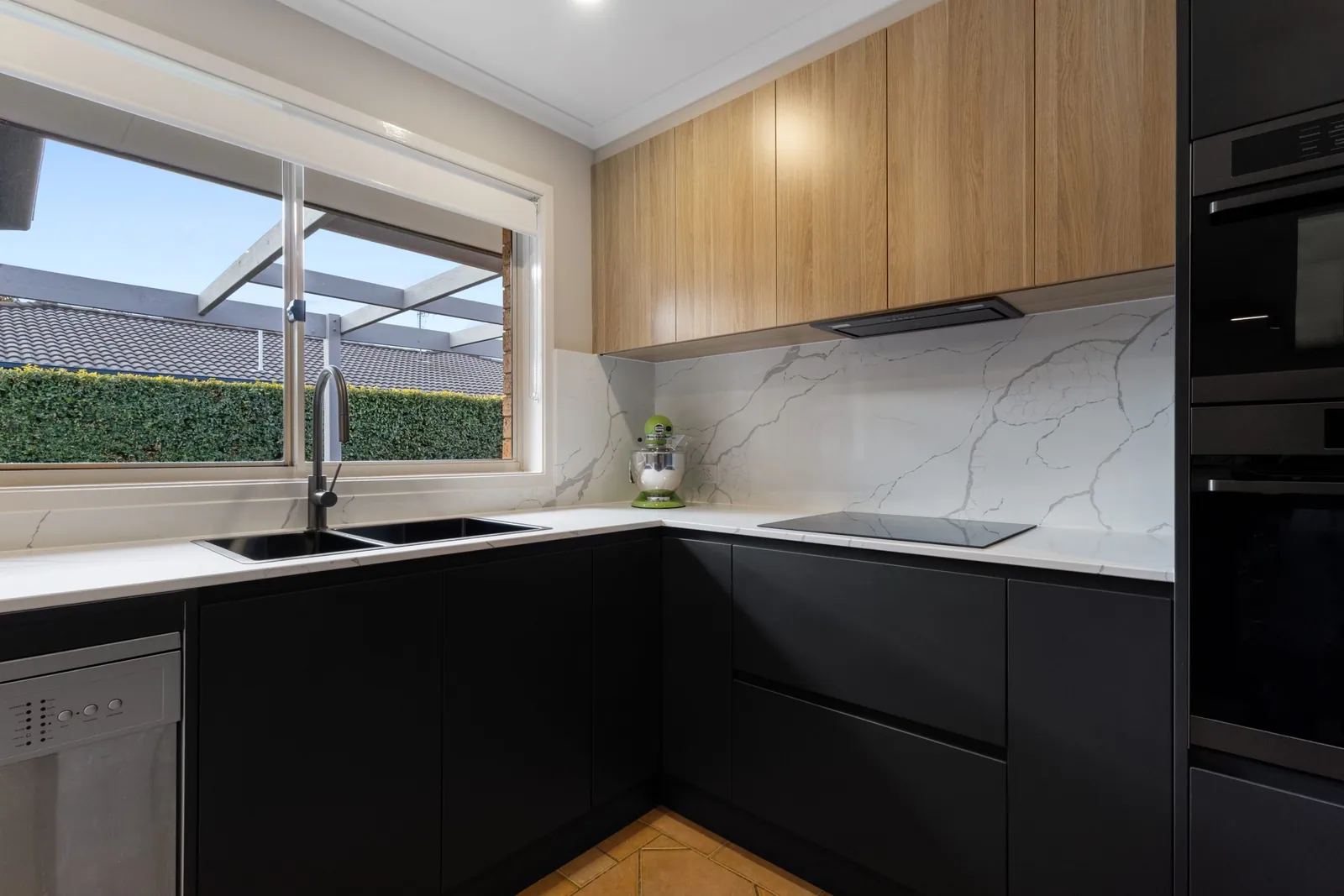 Black cabinetry, cooktop and timber overheads in the Nicholls kitchen