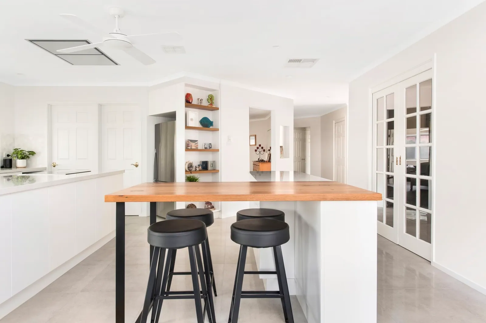 Palmerston kitchen with white cabinetry and a timber breakfast bar with stools