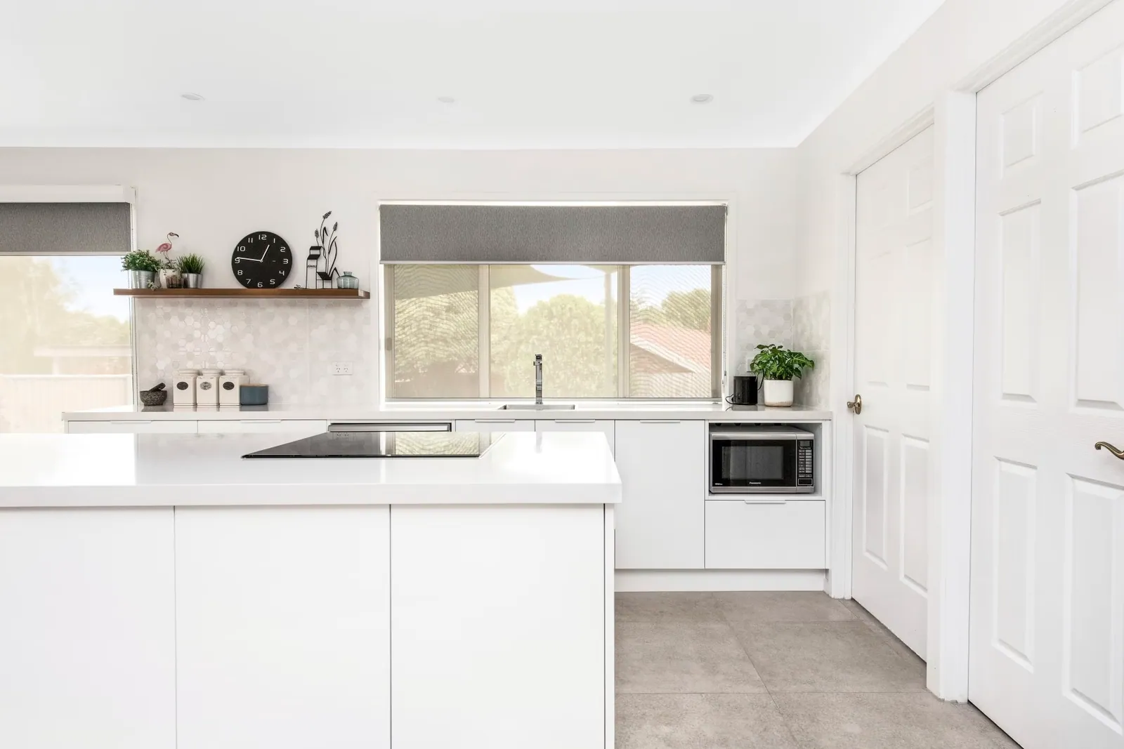 White bench runs, cooktop and window in the Palmerston kitchen