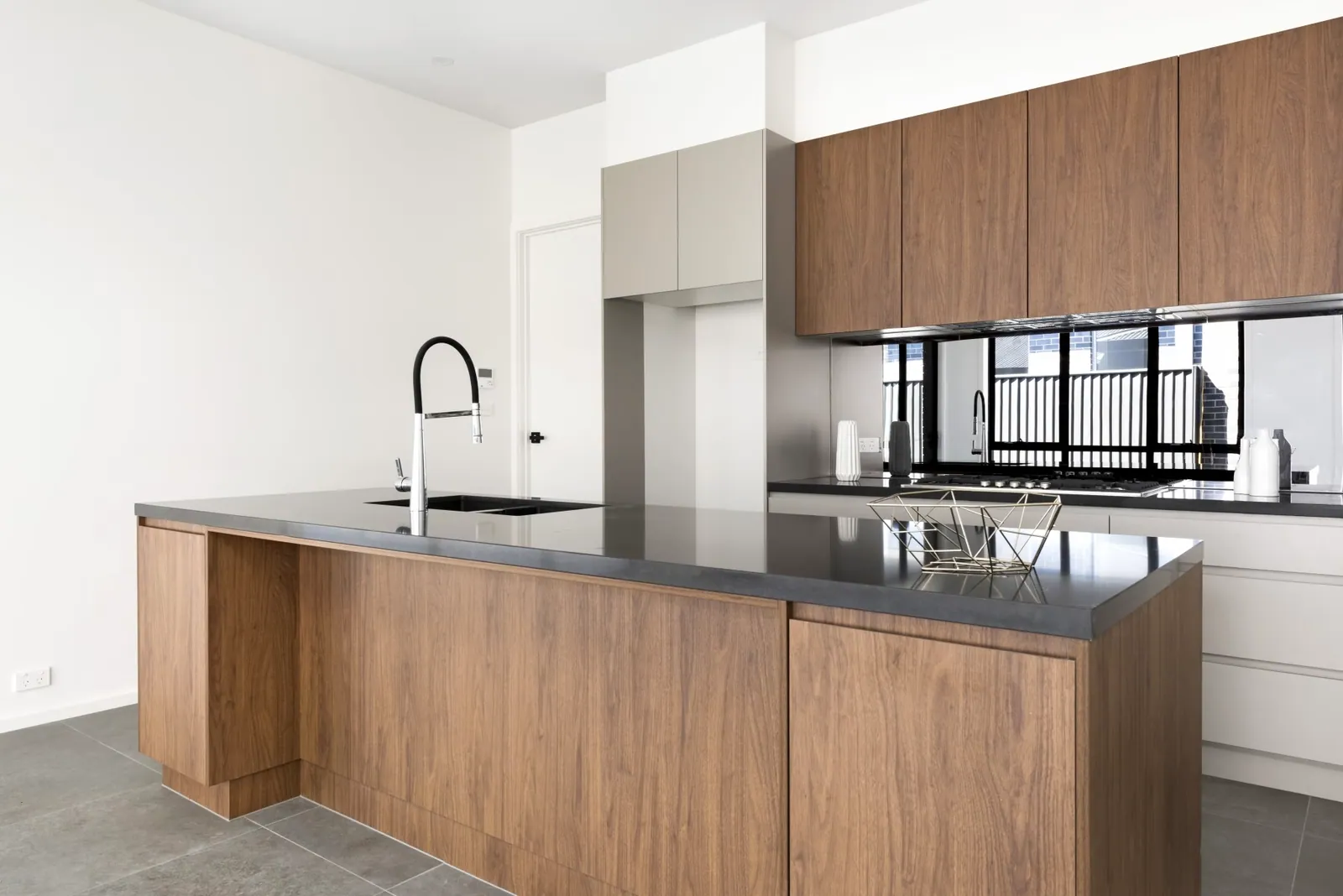 Taylor kitchen with timbergrain island, light grey cabinetry and a dark benchtop