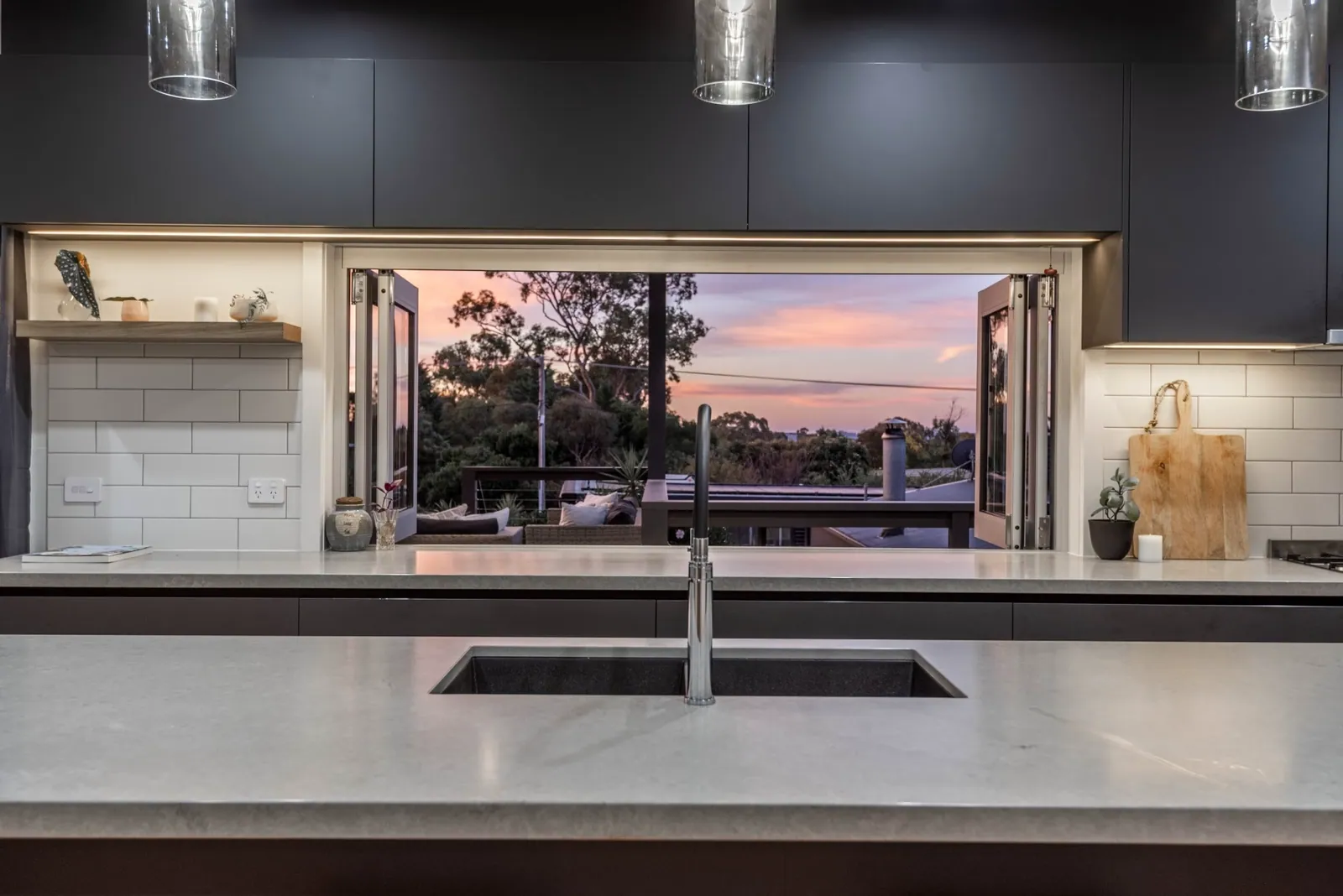 Servery window above the sink in the Weetangera kitchen at dusk