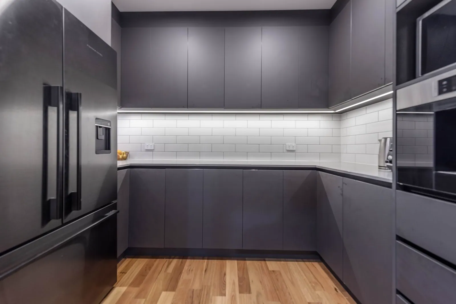Dark grey tall cabinetry and appliance bank in the Weetangera kitchen